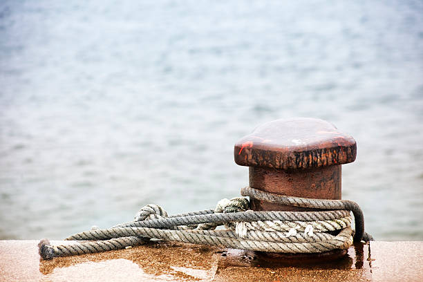 istock Mooring post and thick ropes, sea background. 507579930