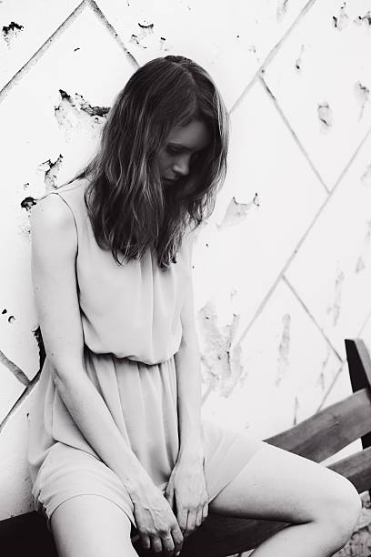 istock Woman sitting on concrete wall background 507581235