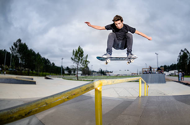 Skateboarder doing a ollie Skateboarder doing a ollie over the rail at the skate park. performing tricks stock pictures, royalty-free photos & images