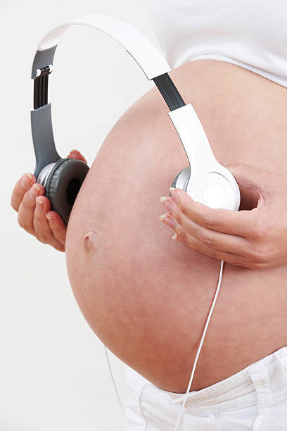 Close Up Of Pregnant Woman Holding Headphones Over Belly Stock Photo -  Download Image Now - iStock