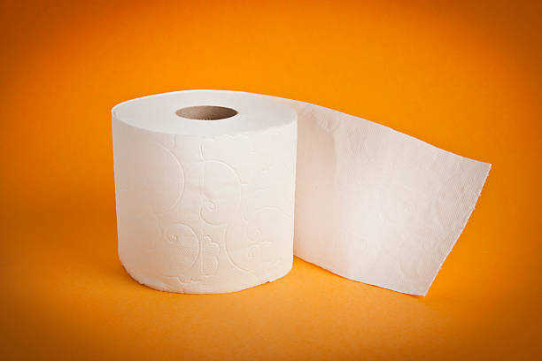 Simple toilet paper on yellow background stock photo