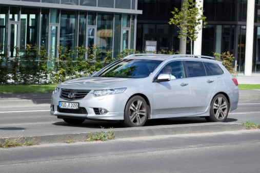 Wiesbaden, Germany - August 14, 2014: A male driver in a Honda Accord Tourer on a street in the city center of Wiesbaden. Honda Accord Tourer is a mid-size station wagon first introduced by Honda in 2008. Honda is a Japanese multinational corporation. Founded in 1948 and headquartered in Tokio it is best-known as a manufacturer of automobiles and motorcycles.