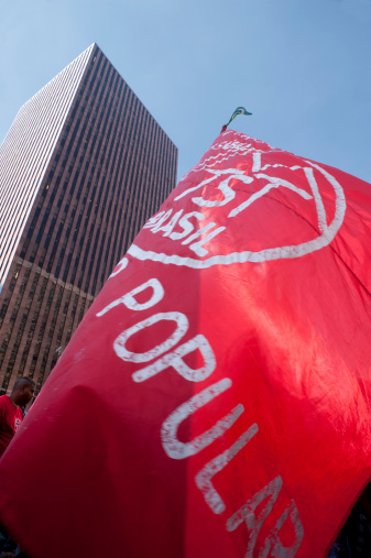 São Paulo, Brazil, July, 03, 2014: Protester with a flag of the landless workers ' movement (MTST) who carried out a march of 20 days in the State to the capital to deliver a letter of demands at the Office of the Presidency of the Republic