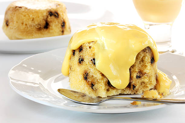 Spotted dick with custard This classic United Kingdom dessert is slowly steamed to produce a moist sponge cake that can be served with a creamy custard sauce custard photos stock pictures, royalty-free photos & images