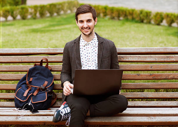 istock young fashion male student sitting on grass 507621045
