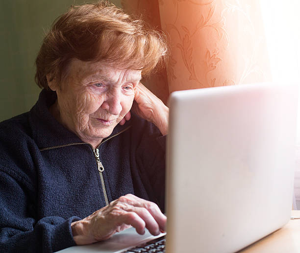 istock Very elderly woman sing laptop computer at home. 507621281