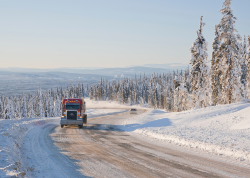 Big Rig Semi-Truck driving up a steep grade on an Arctic Winter Highway in Alaska