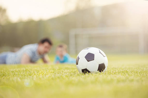 istock Father and son playing football 507623173