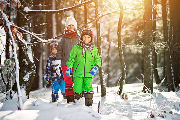 istock Happy kids playing in winter forest 507625880