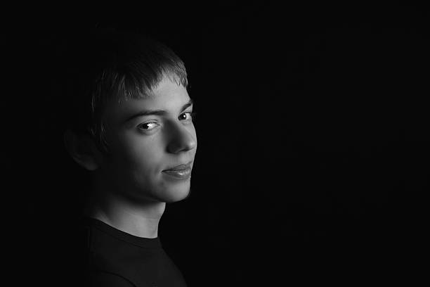 istock Young man slyly looks low key black and white 507626252