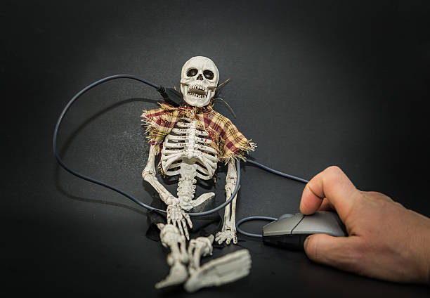 istock skeleton connected to computer mouse operated by human hand 507626900
