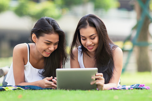 Two Friends Using A Computer Two Friends Using A Tablet Computer Stock Photo - Download Image Now ...