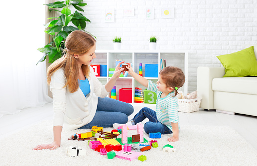 Mother and child daughter playing together, build from the constructor