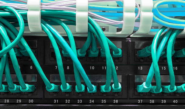 Close up of blue network cables connected to patch panel Close up of blue network cables connected to black patch panel broadband isp stock pictures, royalty-free photos & images