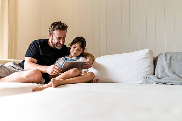 Father and daughter are watching something