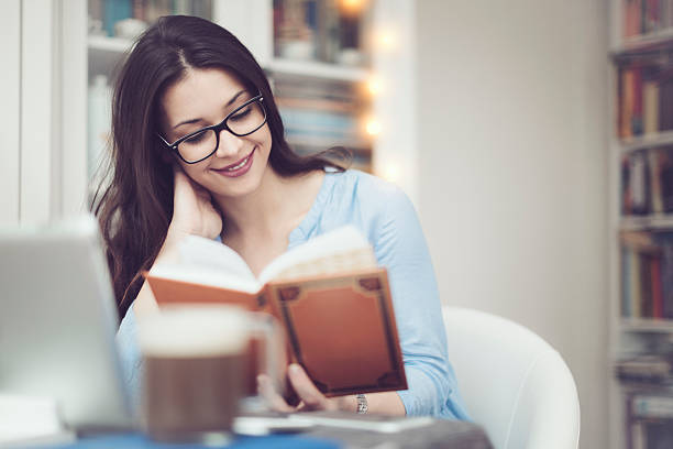 istock Young woman reading a book at home 507630112