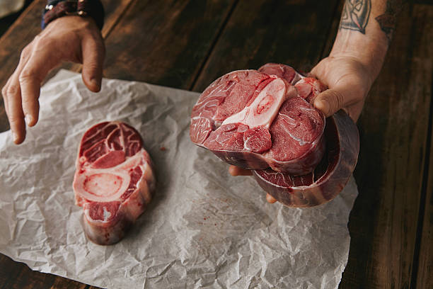 istock Tattooed hand offers piece raw meat steak 507632210