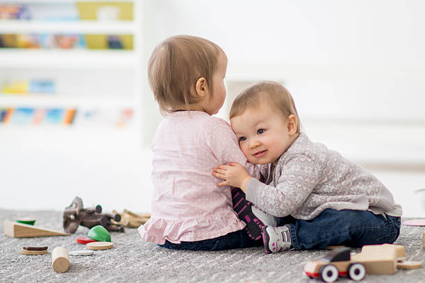 istock Twin sisters hugging in preschool. 507632228