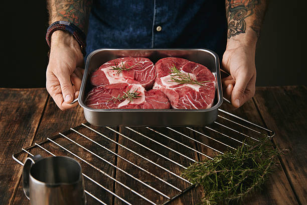 istock tattooed hands offers steaks in pan for camera 507633256