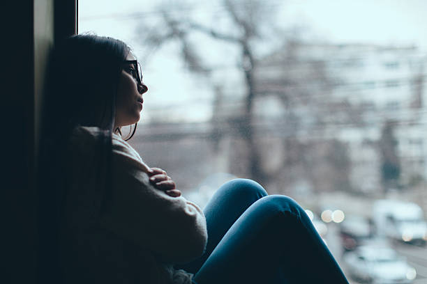 menina adolescente olhando para fora da janela - depression women sadness window imagens e fotografias de stock