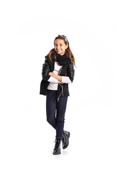 Portrait of cute teenager with hair bow and black leather jacket. Smiling and looking at camera. Isolated on white.