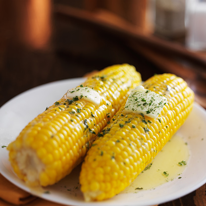 yellow sweet corn on the cob with metled herb butter