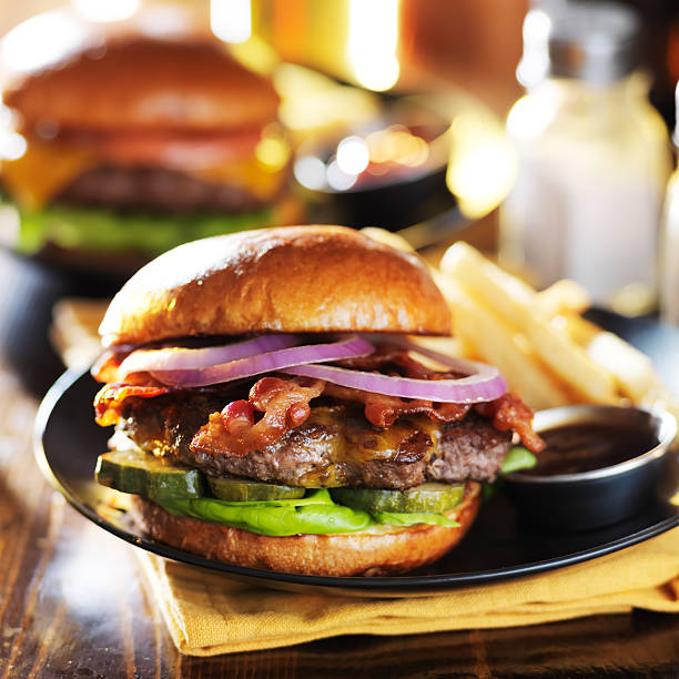 espesso bacon cheeseburger e no restaurante com batatas fritas - bacon cheeseburger imagens e fotografias de stock