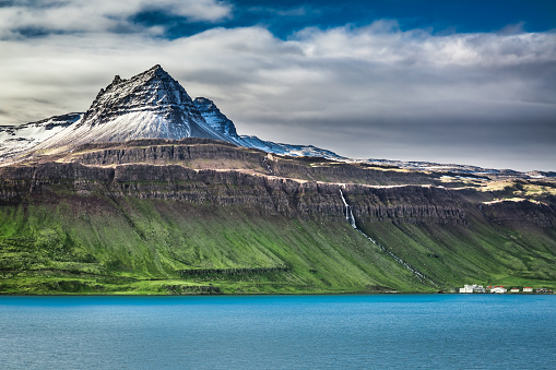 Volcanic mountain over fjord in Iceland.