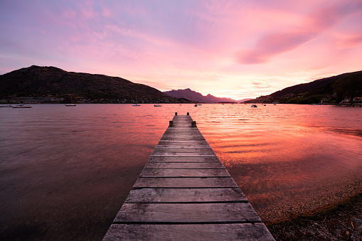 Queenstown, South Island, New Zealand. The fiery red sky of a summer sunset turns the waters of scenic Lake Wakatipu red.