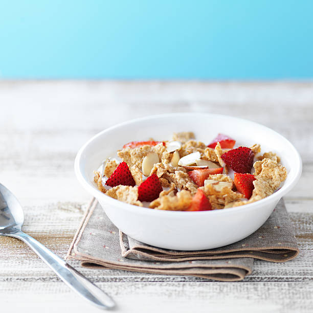 bol de céréales avec des fraises et aux amandes - bran flakes photos et images de collection