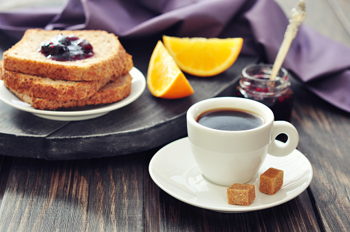 Breakfast with toast, fruit jam and coffee on tray