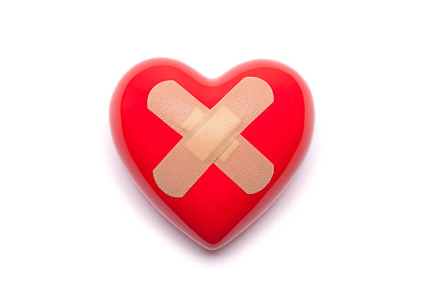 Red heart with adhesive plaster on white background