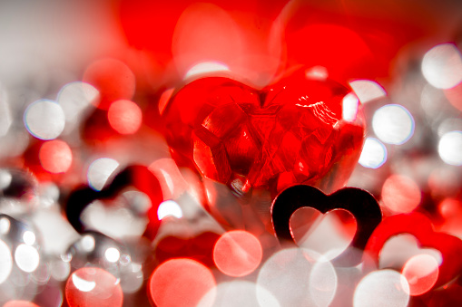 Heart of red glass, Hearts in silhouettes, among bubbles of red and white lights. Transparency and brightness.
