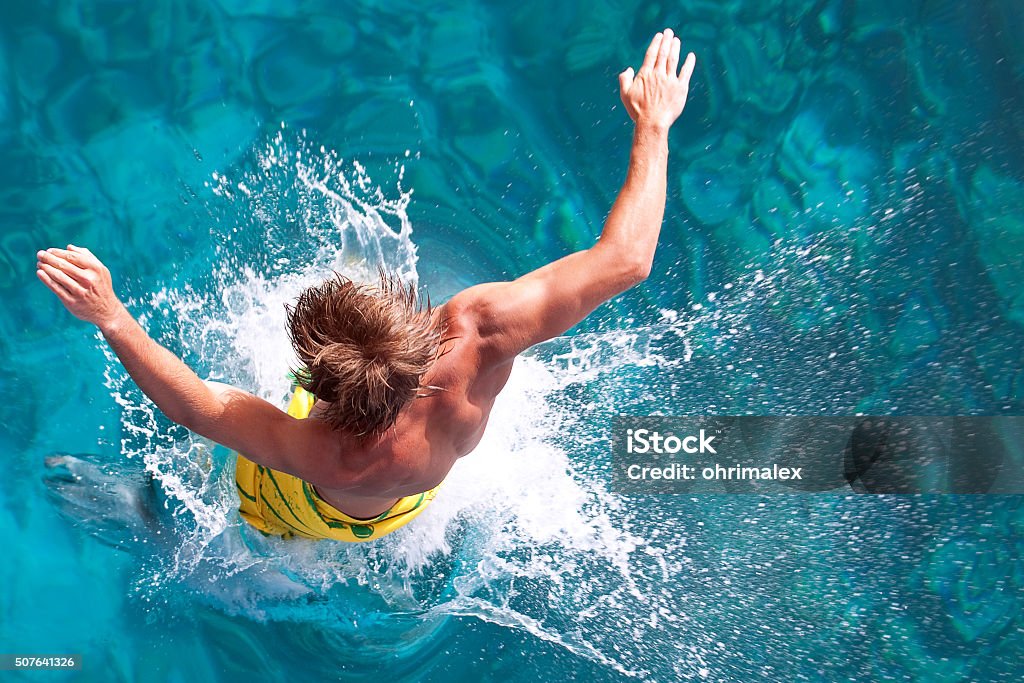 Bathing in Paradise a young man jumps into the turquoise water of the Red Sea Africa Stock Photo