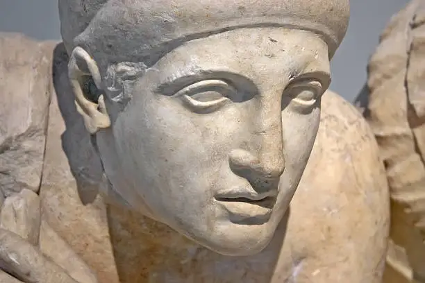 Ancient ruins of the Philippeion at Olympia, Greece. Detail of an ancient Greek statue of a human. Site of the ancient Olympic Games is situated on the Peloponnese. UNESCO world heritage site.