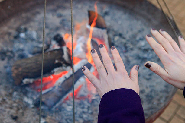 istock woman warming her hands near the fire 507652171
