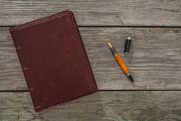 old cuero portátil y pluma estilográfica en old wooden de planchar - note pad leather diary book fotografías e imágenes de stock