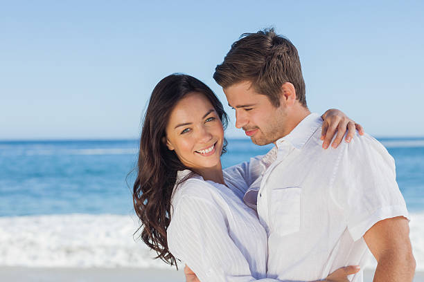 istock Young couple embracing and posing on the beach 507653185