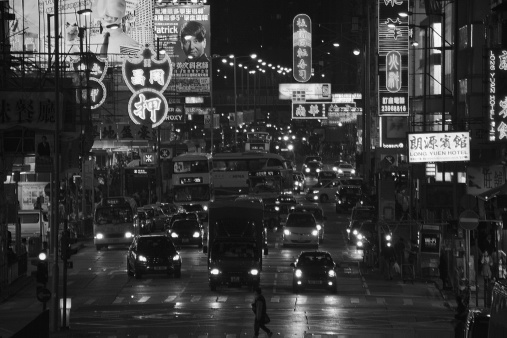 Kowloon, Hong Kong - March 13, 2014: Argyle Street night view, a man crossing the street in the background. It's a major four-lane thoroughfare in Kowloon peninsula, connecting Mong Kok, Ma Tau Wai and Kowloon City