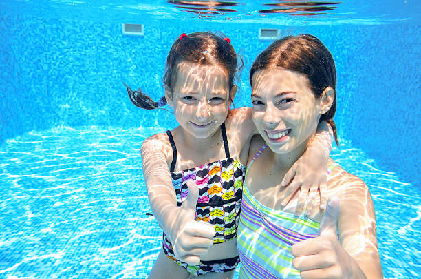 istock Happy active kids swim in pool and play underwater 507657785