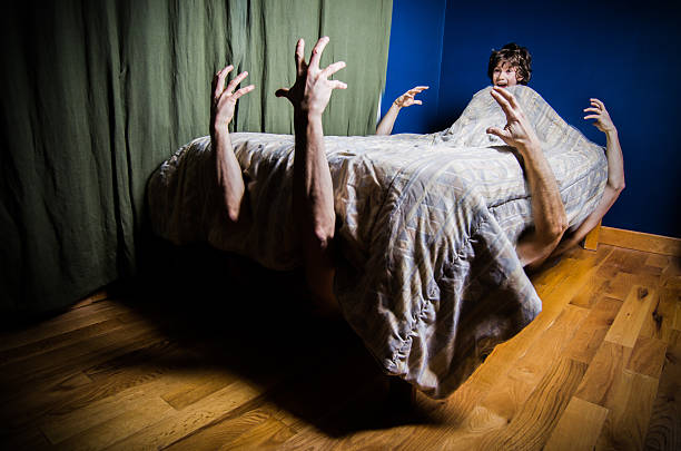 jóvenes chico esconden en la cama con monstruos en la cama - brazo humano fotografías e imágenes de stock