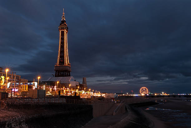 Blackpool Tower in the early evening Early evening on Blackpool beach - lights are all  on. The tower and surrounds  beautifully lit. Blackpool Tower stock pictures, royalty-free photos & images