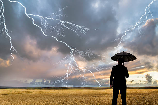 istock Man in black suit with a black umbrella in a storm 507681856