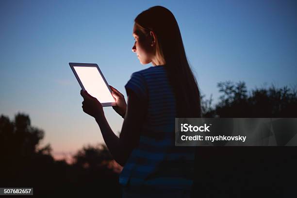 Young Woman Using Digital Tablet At Night Stock Photo - Download Image Now - Computer Monitor, Digital Tablet, Forest