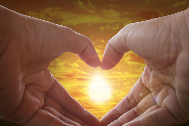 istock Hands made heart shape with sunlight and sky background 507685704