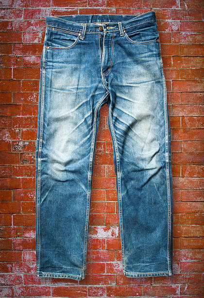istock Blue jeans trouser on orange brick wall 507685828
