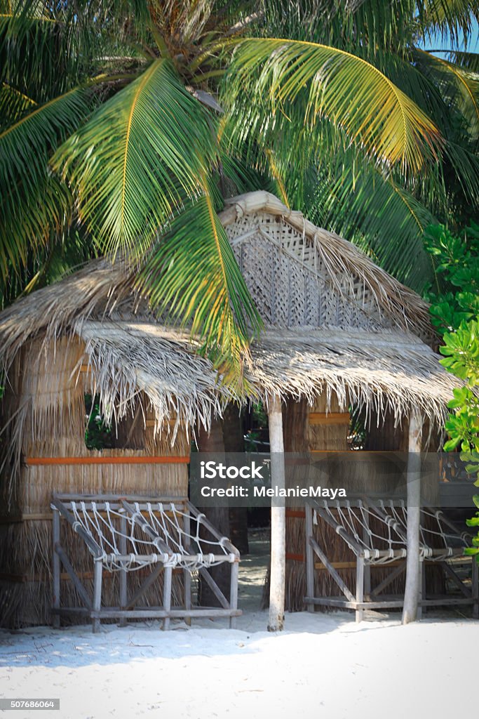 Tropical Beach Hut in Maldives Tropical Beach Hut in Maldives with chairs and Palm Trees by the ocean 2015 Stock Photo