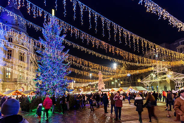 People Gather At The Christmas Market In Downtown Bucharest City Bucharest, Romania - December 23, 2015:  People Gather At The Christmas Market Downtown Bucharest City At Night In The University Square. bucharest people stock pictures, royalty-free photos & images
