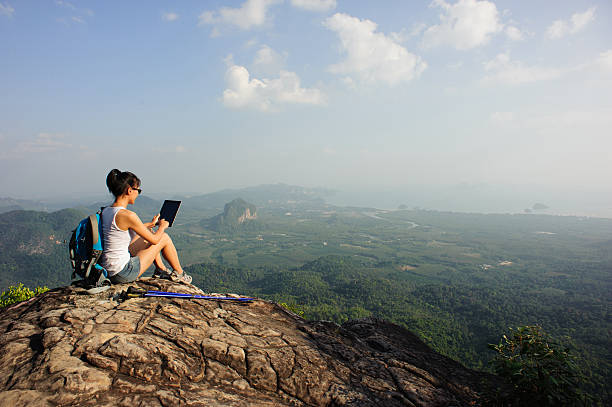 istock woman hiker use digital tablet at mountain peak cliff 507686680