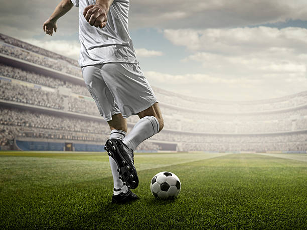 istock Soccer player kicking ball in stadium 507687194